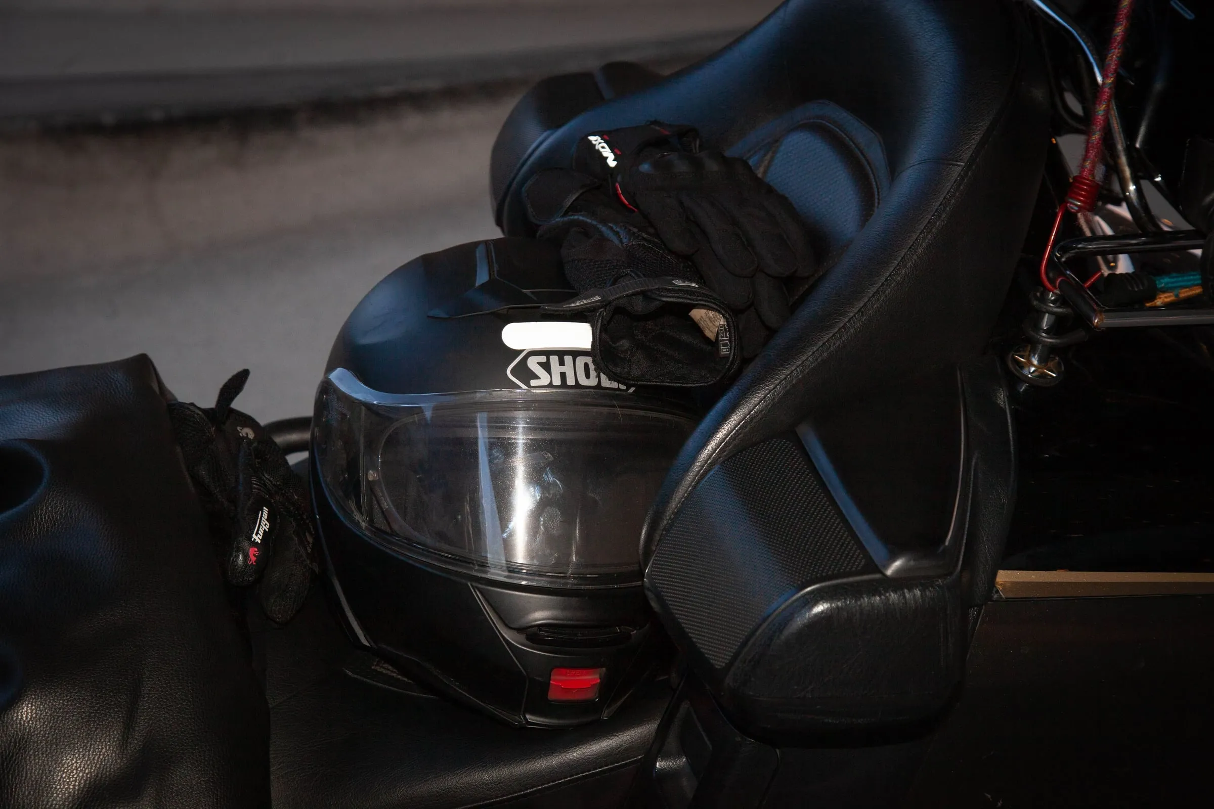 Équipement complet de passager taxi moto : casque, gants, blouson et surchaussures alignés sur une selle Honda Goldwing